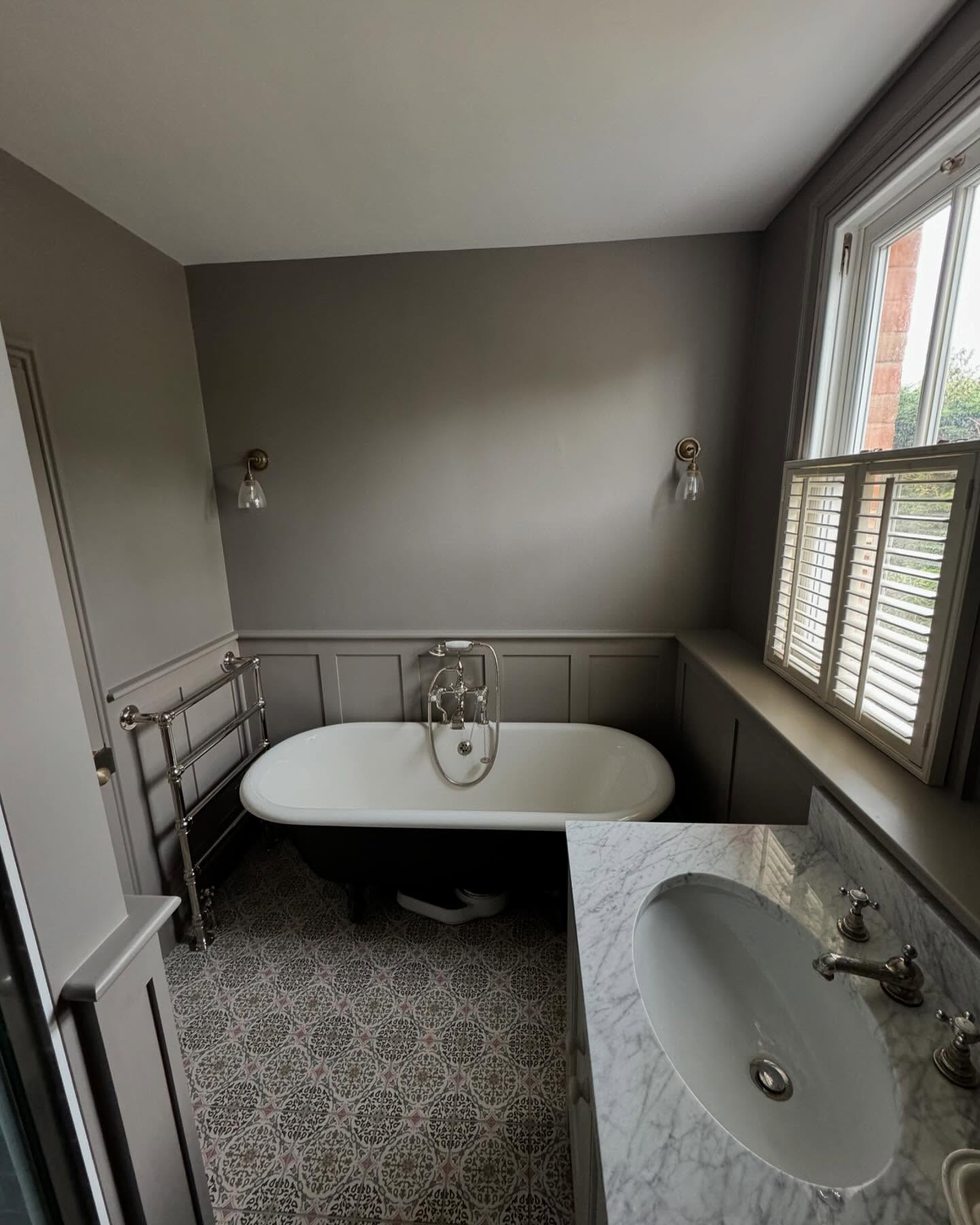 Bathroom with panelled walls and a roll-top bath
