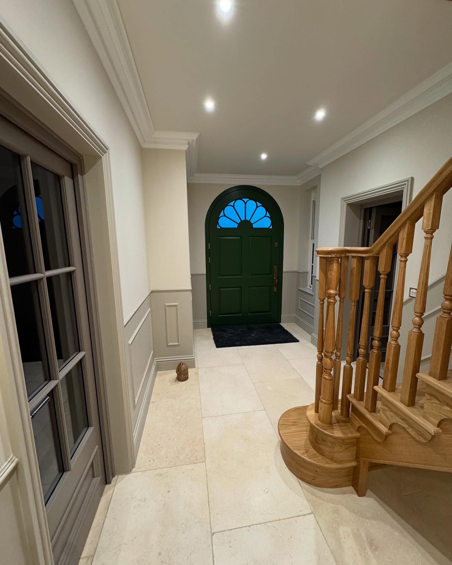 Entrance hall with a green front door and oak staircase