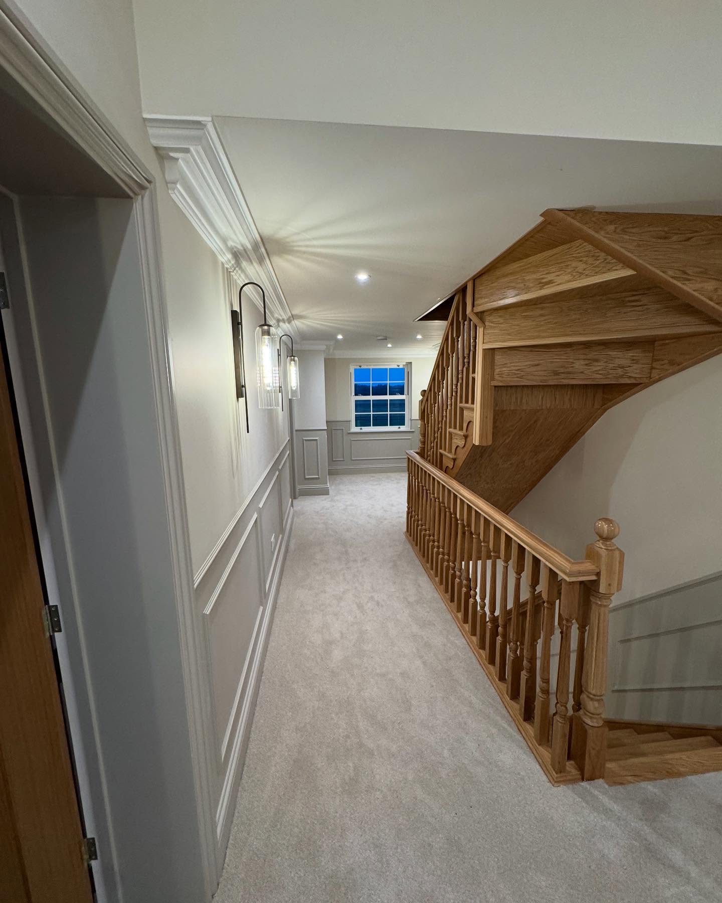 Hallway and oak staircase with freshly painted panelling