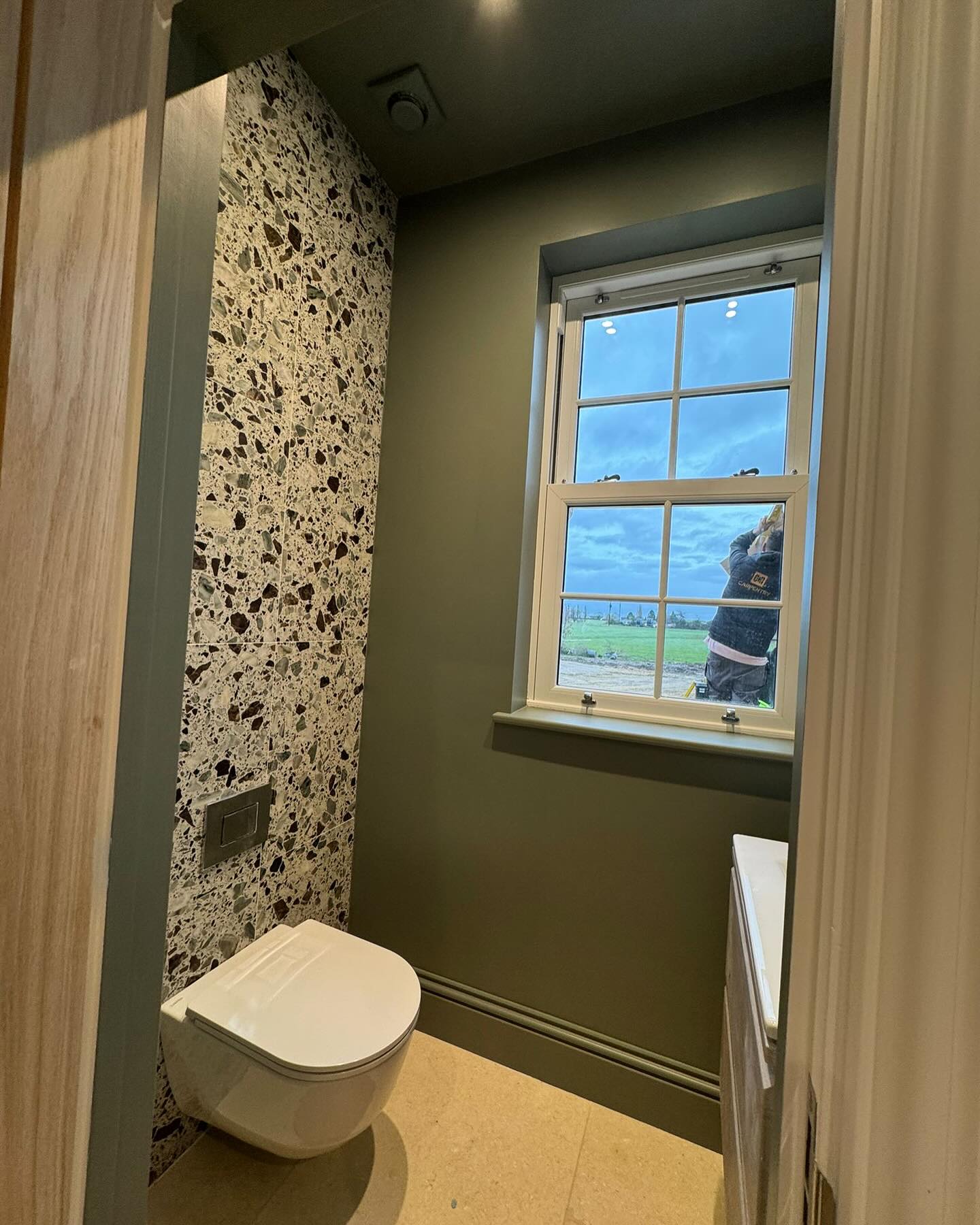 Finished green cloakroom with a sash window